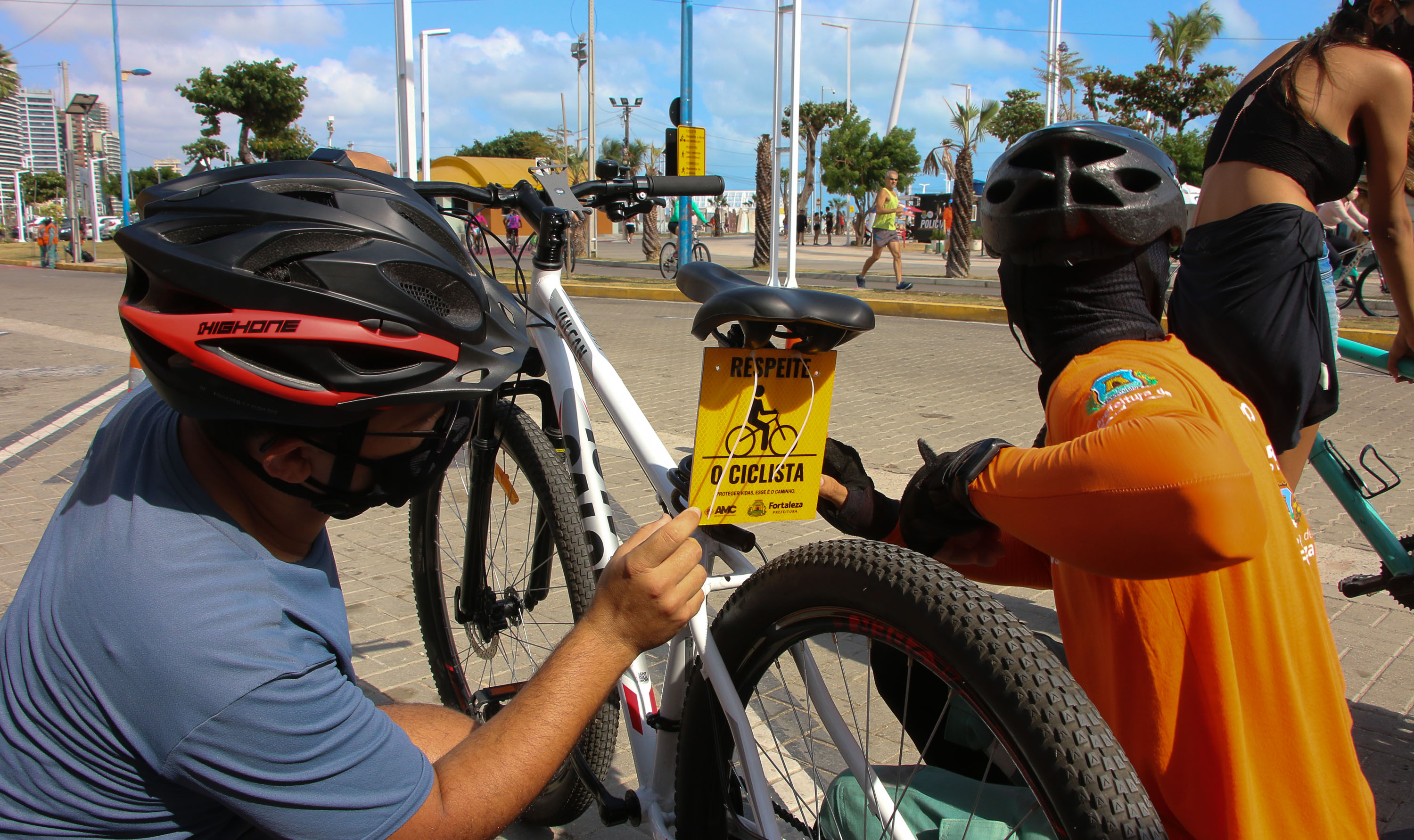 homem coloca placa de respeite o ciclista em uma bicicleta
